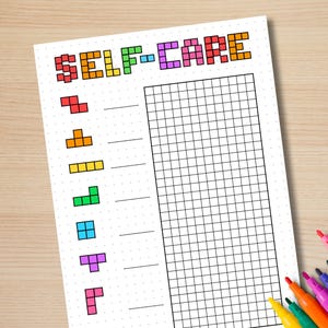 May include: A white self-care planner with a grid and Tetris-style shapes in various colors. The word "SELF-CARE" is written in pixelated, colorful letters at the top. Colored markers are in the bottom right corner.