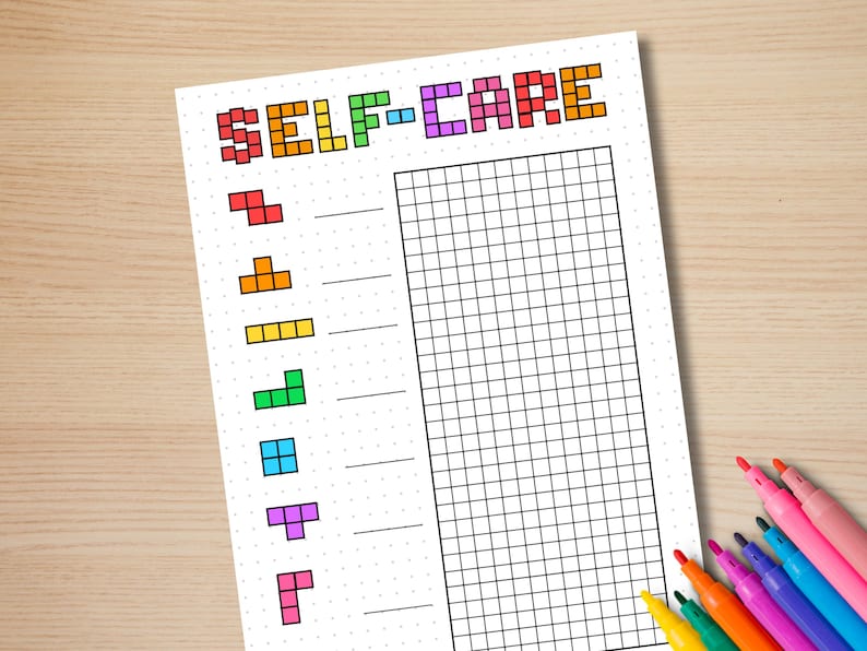 May include: A white self-care planner with a grid and Tetris-style shapes in various colors. The word "SELF-CARE" is written in pixelated, colorful letters at the top. Colored markers are in the bottom right corner.