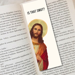 May include: A close-up of a book with the text "IS THAT SMUT?" printed on the cover. The book is open to a page with text about a theory and a picture of Jesus Christ.
