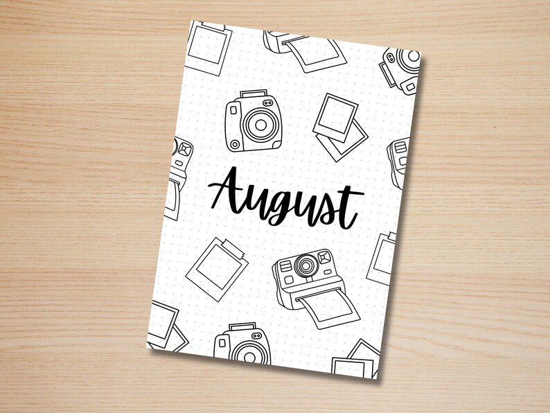 May include: A white printable planner page with a black and white camera pattern and the word "August" in black text.