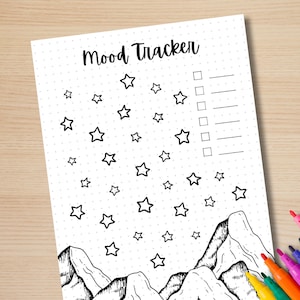 May include: A printable mood tracker featuring a mountain and star design. The tracker has a dotted background and a checklist with lines for writing.