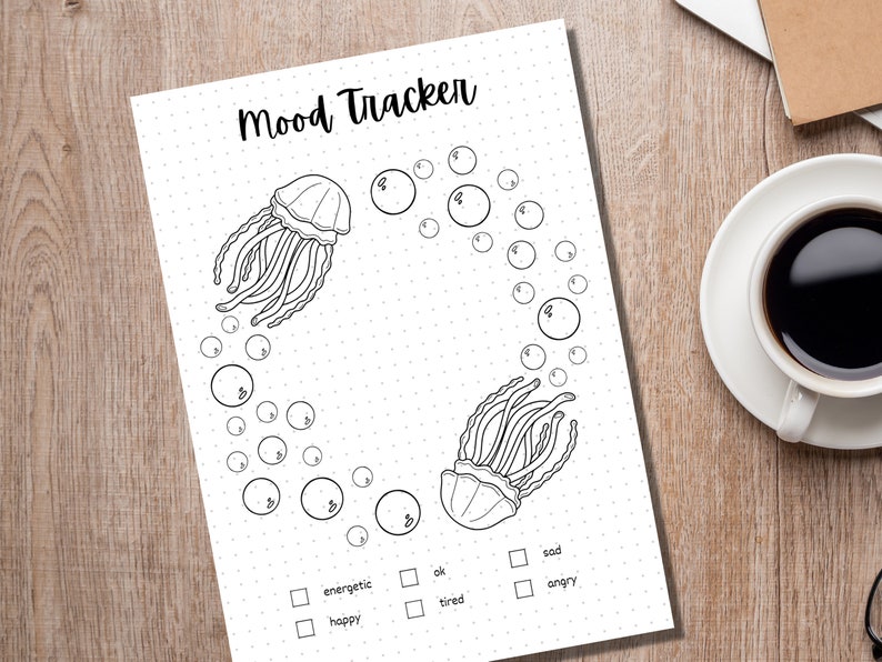 Może przedstawiać: Drukowany tracker nastroju z czarno-białą ilustracją dw&oacute;ch meduz otoczonych bąbelkami. Tracker zawiera listę nastroj&oacute;w: energiczny, szczęśliwy, ok, zmęczony, smutny i zły.