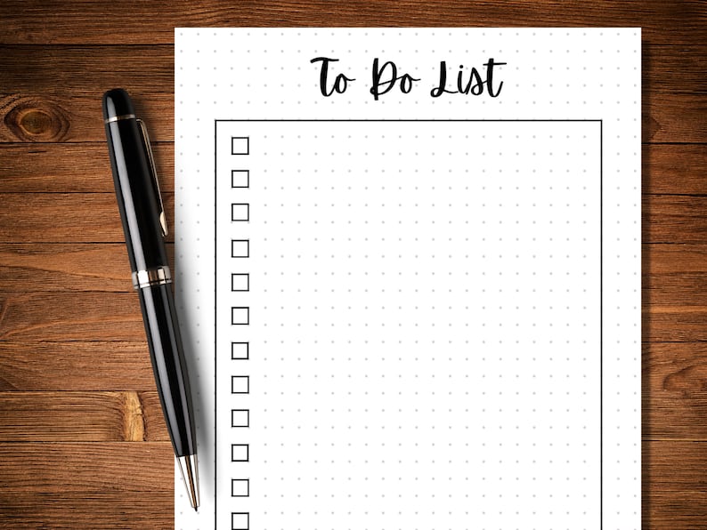 Op de afbeelding: Een witte to-dolijst met een zwarte rand en een zwart stippenpatroon. De titel "To Do List" staat bovenaan de pagina in zwarte cursieve letters. Er zijn 18 lege selectievakjes aan de linkerkant van de pagina.