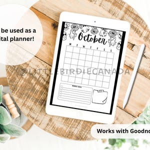 May include: A digital planner displayed on a white tablet, featuring a black and white October calendar layout with ghost and floral illustrations. The tablet is on a wooden surface, with text that says "Can be used as a digital planner!" and "Works with Goodnotes!"