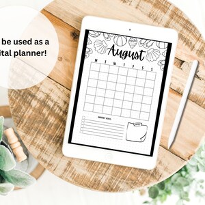 May include: A digital planner for the month of August with a beach theme. The planner has a black and white design with seashells, flip flops, and a beach ball. The planner is on a tablet with a white stylus.