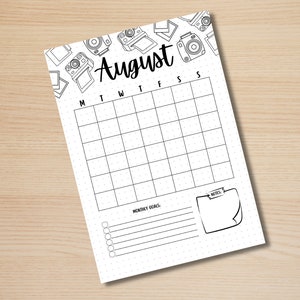 May include: A printable August calendar with a dotted grid and a section for monthly goals and notes. The calendar is decorated with a border of hand-drawn cameras.