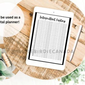 May include: A white digital tablet with a black border displaying a printable intermittent fasting tracker. The tracker is a grid with numbers 1-31 and days of the week. The text "Intermittent Fasting" is at the top of the tracker. The tablet is on a wooden surface.