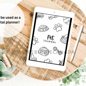 K&ouml;nnte beinhalten: Ein wei&szlig;es digitales Tablet mit einem schwarzen Bildschirm, auf dem ein Cover f&uuml;r ein Haustier-Tagebuch angezeigt wird. Das Cover zeigt eine Schwarzwei&szlig;illustration einer Hundenapf, eines Hundeknochens, einer Hundeleine, eines Hundespielzeugs, eines Hundepfotenabdrucks, einer Hundetransportbox und den Text "Pet Journal".