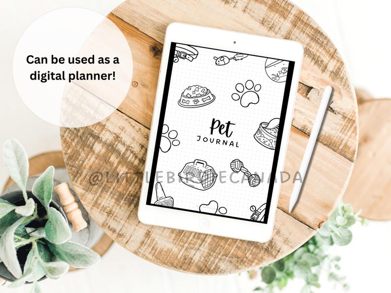 K&ouml;nnte beinhalten: Ein wei&szlig;es digitales Tablet mit einem schwarzen Bildschirm, auf dem ein Cover f&uuml;r ein Haustier-Tagebuch angezeigt wird. Das Cover zeigt eine Schwarzwei&szlig;illustration einer Hundenapf, eines Hundeknochens, einer Hundeleine, eines Hundespielzeugs, eines Hundepfotenabdrucks, einer Hundetransportbox und den Text "Pet Journal".