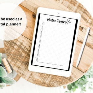 May include: A white tablet with a black screen displaying a water tracker with a dotted grid and the text "Water Tracker" in black cursive. A white stylus is lying on a wooden surface next to the tablet.