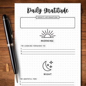 May include: A black and white printable daily gratitude journal with a dotted background. The journal has sections for morning and night. The morning section has a sun icon and the text "I'm looking forward to:" with three lines for writing. The night section has a moon icon and the text "I'm grateful for:" with two lines for writing.