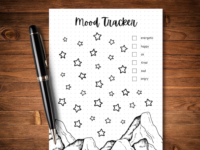 May include: A black and white printable mood tracker featuring a mountain and star design. The tracker includes a checklist with the following options: energetic, happy, ok, tired, sad, angry.