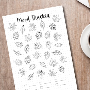 Puede incluir: Un rastreador de humor imprimible con un dise&ntilde;o de hojas en blanco y negro. El rastreador tiene un t&iacute;tulo que dice "Mood Tracker" y tiene espacio para entradas diarias.