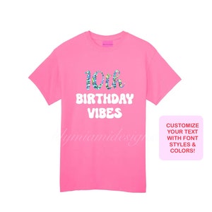 以下が含まれることがあります： ピンクのTシャツに「10th Birthday Vibes」という白い文字が書かれており、数字の10にはキラキラ光る虹のデザインが施されています。