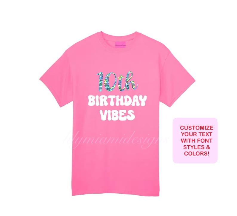 以下が含まれることがあります： ピンクのTシャツに「10th Birthday Vibes」という白い文字が書かれており、数字の10にはキラキラ光る虹のデザインが施されています。