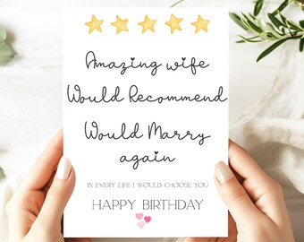 以下が含まれることがあります： 「Amazing wife, Would Recommend, Would Marry again」という黒い筆記体の文字が書かれた白いグリーティングカード。カードの上部には5つの黄色の星のイラストがあり、下部には「Happy Birthday」という文字があります。