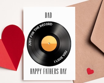 May include: A white card with the text "DAD" at the top. Below the text is a black vinyl record with the text "JUST FOR THE RECORD" written around the outside edge. The record has a gold center with the text "I LOVE YOU" written around the outside edge. The text "HAPPY FATHERS DAY" is printed below the record.