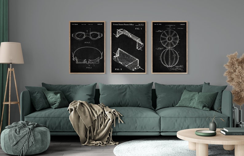 May include: Three black and white patent drawings framed in wood. The drawings depict a pair of swimming goggles, a football goal, and a basketball. The drawings are hung on a grey wall above a green sofa.
