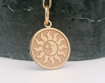 May include: Gold pendant necklace featuring a sun and moon design. The sun has a crescent moon inside with a star.