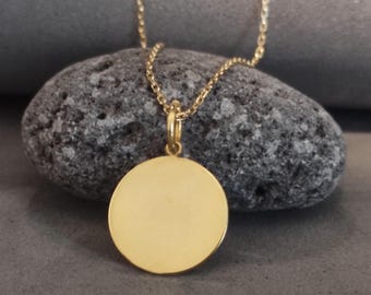 Puede incluir: Un collar de cadena de oro con un colgante redondo de oro liso.