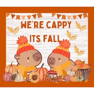 Pode incluir: Dois capivaras marrons usando chapéus e cachecóis de tricô vermelho e amarelo estão cercados por abóboras, abóboras e folhas de outono. O texto "We're Cappy It's Fall" está escrito em um fundo de madeira branca.