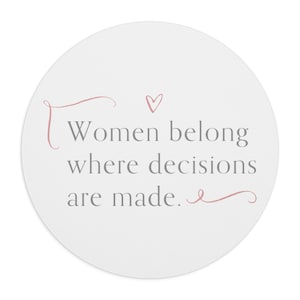 May include: A white round sticker with a pink heart and the text "Women belong where decisions are made."