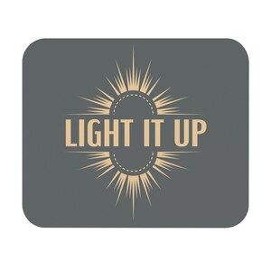 Puede incluir: Un fondo gris con un diseño de estrella dorada y el texto "LIGHT IT UP" en el centro.