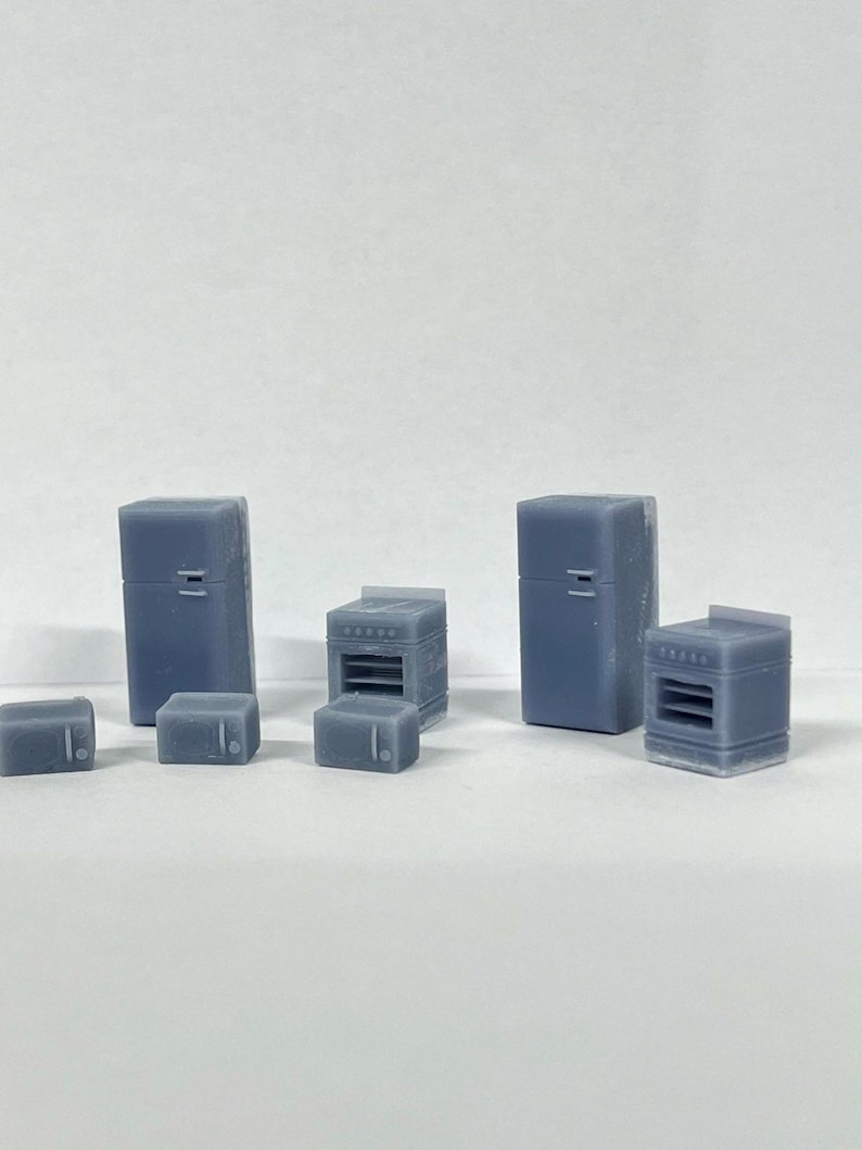 Puede incluir: Un conjunto de electrodom&eacute;sticos de cocina en miniatura, que incluye dos refrigeradores, dos hornos y tres microondas. Los electrodom&eacute;sticos est&aacute;n hechos de pl&aacute;stico gris claro y miden aproximadamente 5 cm de alto.