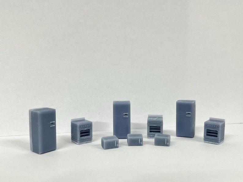 Puede incluir: Un conjunto de electrodom&eacute;sticos de cocina en miniatura, que incluye un refrigerador, un horno, un microondas y una tostadora. Los electrodom&eacute;sticos est&aacute;n hechos de pl&aacute;stico gris claro y tienen aproximadamente 2,5 cm de alto.