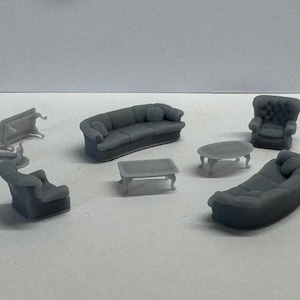 May include: A set of miniature furniture including a grey sofa, two armchairs, a coffee table, and an oval end table. The furniture is made of plastic and is designed for model railway or dollhouse decor.