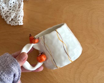 Elegante taza de cerámica hecha a mano con mini calabazas en el asa, diseño otoñal, taza artesanal.
