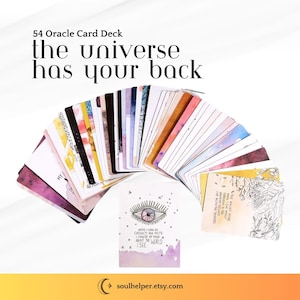 May include: A deck of 54 oracle cards fanned out, with the text "the universe has your back." The cards have watercolor designs and inspirational quotes. One card features an eye illustration and the text "I see."