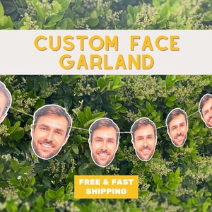 May include: A garland of custom face cutouts, featuring a smiling man's face repeated throughout the garland. The garland is strung on a white string and hangs against a green leafy background. The text "CUSTOM FACE GARLAND" is displayed in yellow letters at the top of the image. The text "FREE & FAST SHIPPING" is displayed in yellow letters at the bottom of the image.