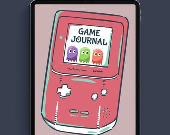 May include: A pink and green handheld game console with a screen that says "GAME JOURNAL". Three pixelated ghosts are on the screen. The console has a plus sign button, two round buttons, and a directional pad.