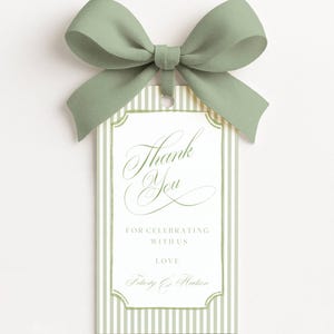 May include: A rectangular gift tag featuring a sage green and white vertical striped border with a decorative frame. The text reads Thank You, FOR CELEBRATING WITH US, LOVE, and Felicity & Hudson. A sage green ribbon bow is attached at the top.