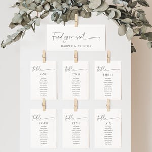 May include: A wedding seating chart with the text "Find your seat" and the names "Harper & Preston" at the top. Below are six table assignments, each with a list of names, clipped to a white board with wooden clothespins.
