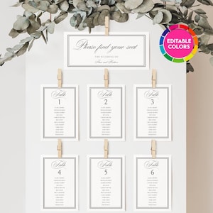 May include: A white wedding seating chart display featuring a header card reading Please find your seat and six individual table cards numbered one through six. Each card is attached with a wooden clip to a white board decorated with eucalyptus.