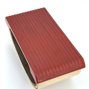 Tampone assorbente in bachelite lucida color rosso mattone, risalente agli anni '40, in stile art decò