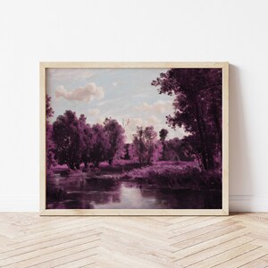 May include: A framed landscape painting of a river flowing through a forest. The trees are a vibrant purple color, and the sky is a soft blue with white clouds. The painting is set against a white wall.