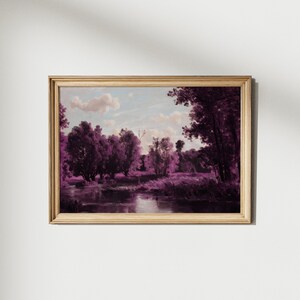 May include: A framed painting of a landscape with a river and trees in shades of purple. The sky is a light blue with white clouds.