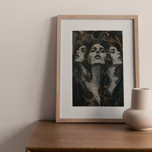 May include: A framed print of a woman's face with a dark background and gold accents. The woman's face is repeated three times, each with a slightly different expression. The print is in a light wood frame.