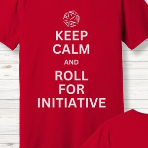 May include: Red t-shirt with white text that reads "Keep Calm and Roll for Initiative". A white 20-sided die is above the text.