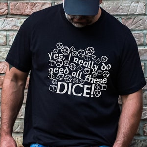 May include: A black t-shirt with a white graphic design of dice and the text "Yes, I really do need all these DICE!"