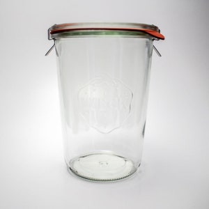 Pu&ograve; includere: Vaso di vetro trasparente con coperchio rosso e verde e chiusura a clip metallica. Il vaso ha una forma cilindrica e un'ampia apertura. La parola "WECK" &egrave; in rilievo. Ideale per la conservazione.