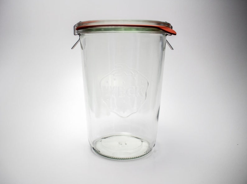 Pu&ograve; includere: Vaso di vetro trasparente con coperchio rosso e verde e chiusura a clip metallica. Il vaso ha una forma cilindrica e un'ampia apertura. La parola "WECK" &egrave; in rilievo. Ideale per la conservazione.