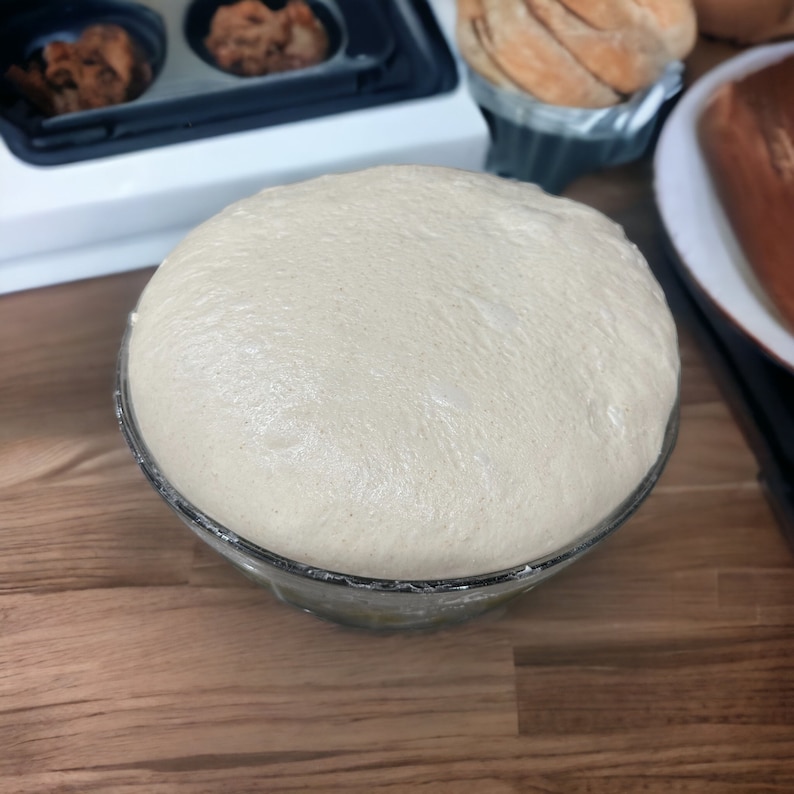 K&ouml;nnte beinhalten: Nahaufnahme einer Glassch&uuml;ssel gef&uuml;llt mit hellem braunen Teig, der aufgegangen ist und zum Backen bereit ist.