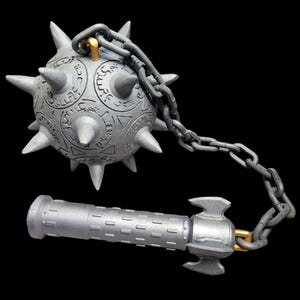 May include: A silver mace, featuring a spiked ball head linked by a chain to a cylindrical handle. The ball head is adorned with engraved patterns and sharp spikes. The handle has a textured design and a hammer-like end. The background is black.