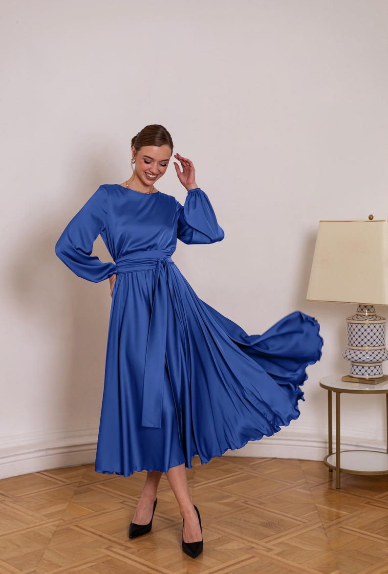 a woman in a blue dress standing in a room