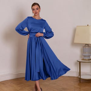 a woman in a blue dress standing in a room
