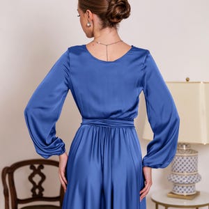 a woman in a blue dress standing in a room